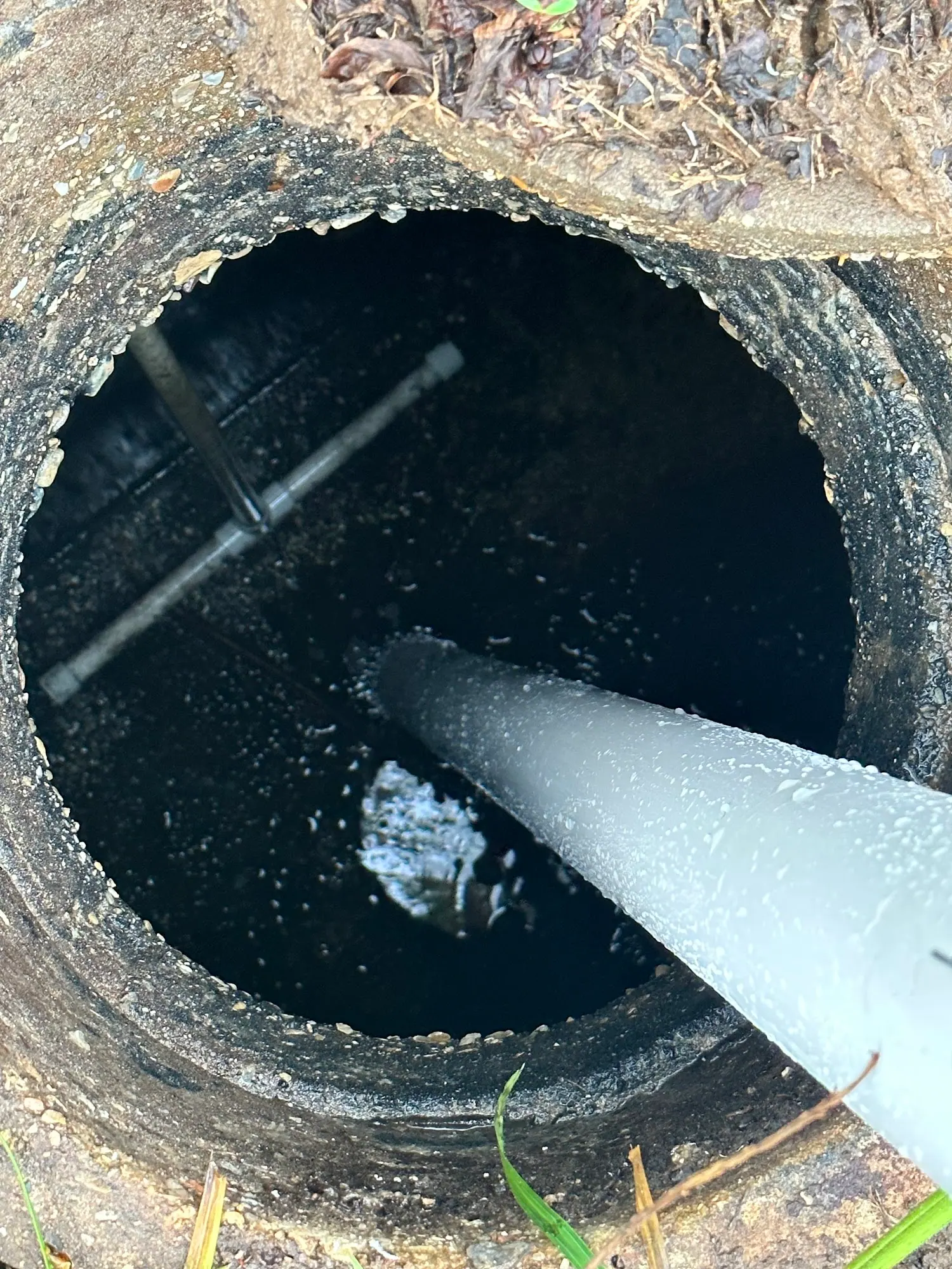 Vacuum hose inside an open septic tank